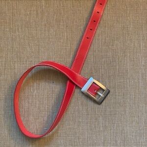 Red leather belt with a silver buckle